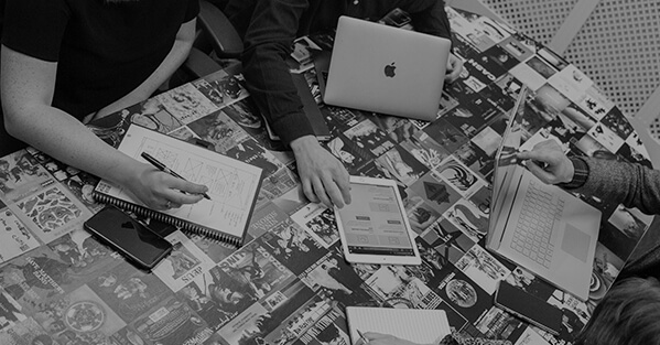 Group of people in a meeting with notebooks and laptops